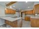 Kitchen featuring an island with a cooktop, granite countertops, wooden cabinets and stainless steel appliances at 3518 Woodale Rd, Indianapolis, IN 46234