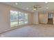 Bright living room featuring a ceiling fan, neutral carpeting, and a large picture window overlooking the front yard at 3518 Woodale Rd, Indianapolis, IN 46234