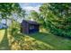 View of the backyard shed surrounded by mature trees at 3518 Woodale Rd, Indianapolis, IN 46234