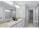Modern bathroom with dual sinks, spacious mirror, and glass-enclosed shower with a walk-in closet view at 3650 Merchmont Rd, Bargersville, IN 46106