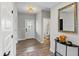 Bright entryway featuring hardwood floors, a stylish mirror, and a view of the powder room at 3650 Merchmont Rd, Bargersville, IN 46106