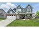 Attractive home boasts a brick and siding exterior, with a welcoming front porch and well-maintained lawn at 3650 Merchmont Rd, Bargersville, IN 46106