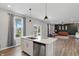 Bright kitchen with large island, stainless steel appliances, and view to the yard at 3650 Merchmont Rd, Bargersville, IN 46106