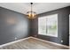 Room featuring gray walls, wood floors, a modern light fixture, and a large window at 3650 Merchmont Rd, Bargersville, IN 46106
