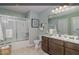 Well-lit bathroom featuring a double vanity, decorative wallpaper, a shower over tub, and modern fixtures at 3933 Wren Dr, Brownsburg, IN 46112