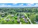 An aerial view of a green, tree-filled neighborhood featuring various homes and blue skies on a bright day at 405 N Church St, Mooresville, IN 46158