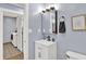 Bathroom with a white sink vanity, framed picture, towel ring, and a washing machine in the next room at 405 N Church St, Mooresville, IN 46158