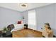 Bright bedroom with neutral walls, a big window and a toy dog at 405 N Church St, Mooresville, IN 46158