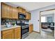 Modern kitchen with stainless steel appliances, wooden cabinets and view to an adjacent living room at 405 N Church St, Mooresville, IN 46158