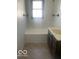 Well-lit bathroom features a tub-shower combo, toilet and dark wood vanity at 416 W 21St St, Anderson, IN 46016