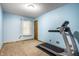 Bright bedroom features blue walls, carpet, window, and a treadmill for convenient home workouts at 4309 Clayburn Dr, Indianapolis, IN 46268