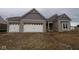 Charming single Gathering home features brick exterior, white garage doors, and architectural roofline details at 4999 Hummingbird Dr, Brownsburg, IN 46112