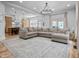 Spacious living room features a large sectional sofa, chandelier, wood floors, and open access to the kitchen at 545 Fletcher Ave, Indianapolis, IN 46203
