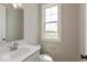 Bright half bathroom featuring a modern vanity, toilet, and a large window at 6038 Windsor Dr, McCordsville, IN 46055