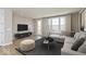 Cozy living room features a large window, comfortable seating, stylish decor, and hardwood flooring at 6038 Windsor Dr, McCordsville, IN 46055