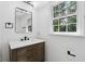 Bathroom features a modern vanity with a stylish mirror and natural light from a window at 6838 Johnson Rd, Indianapolis, IN 46220
