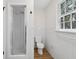 Bathroom with a stand up shower, toilet, wood look floors, and a view to the outside at 6838 Johnson Rd, Indianapolis, IN 46220