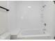 Bathroom features a white shower-tub combo with shelving and modern fixtures for a clean aesthetic at 6838 Johnson Rd, Indianapolis, IN 46220