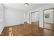 Bedroom featuring hardwood floors, closet with sliding mirror doors and natural light at 6838 Johnson Rd, Indianapolis, IN 46220