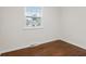 Bright bedroom featuring hardwood floors, neutral walls and large window with outside view at 6838 Johnson Rd, Indianapolis, IN 46220