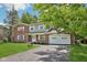 Two-story brick home with an attached garage and a driveway shaded by mature trees at 6838 Johnson Rd, Indianapolis, IN 46220
