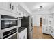 Bright kitchen featuring stainless steel appliances and white cabinetry at 6838 Johnson Rd, Indianapolis, IN 46220