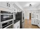 Bright kitchen featuring white cabinets, stainless steel appliances, and hardwood floors at 6838 Johnson Rd, Indianapolis, IN 46220