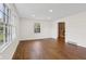 Bright living room with hardwood floors, large windows, and view of brick fireplace at 6838 Johnson Rd, Indianapolis, IN 46220