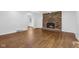 Spacious living room featuring a brick fireplace and gleaming hardwood floors at 6838 Johnson Rd, Indianapolis, IN 46220