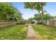 Spacious backyard featuring a brick pathway, green lawn, and wooden fence, perfect for outdoor enjoyment and privacy at 702 S Keystone Ave, Indianapolis, IN 46203