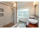 Bright bathroom featuring a subway tile shower, a white toilet, and a wooden vanity with double sinks at 702 S Keystone Ave, Indianapolis, IN 46203