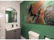 Elegant half bathroom with a gray vanity, sleek faucet, modern mirror, and vibrant art at 702 S Keystone Ave, Indianapolis, IN 46203