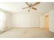 A spacious bedroom with a ceiling fan, neutral paint, and multiple closets for storage solutions at 7317 Lions Head Dr # A, Indianapolis, IN 46260