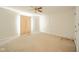 The bedroom has neutral carpet, a ceiling fan, and a large window for natural light at 7317 Lions Head Dr # A, Indianapolis, IN 46260