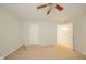 A cozy bedroom with neutral walls, carpeted floors, a ceiling fan, and easy access to multiple doors at 7317 Lions Head Dr # A, Indianapolis, IN 46260