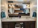 Bathroom showcasing a double vanity, modern lighting, and unique wood-look accent wall at 7511 Eddie Ln, Camby, IN 46113