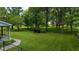 Spacious backyard with lush lawn, mature trees, and partial fencing, creating a serene outdoor space at 7516 S County Road 300 W, Clayton, IN 46118