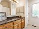 Bathroom features granite countertops, wooden cabinets, and great natural light from the window at 7685 River Rd, Indianapolis, IN 46240