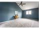 Vaulted bedroom with blue accent wall, ceiling fan, and neutral carpet at 7685 River Rd, Indianapolis, IN 46240