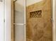 Shower stall features decorative tile, glass door, and built in storage nook for bath accessories at 7685 River Rd, Indianapolis, IN 46240