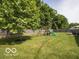 Large backyard with lush green grass, a mature tree, and play-set to provide a perfect outdoor retreat at 774 Courtney Cir, Danville, IN 46122