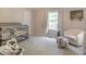 Bright bedroom with a large window, comfortable chair, and crib at 774 Courtney Cir, Danville, IN 46122