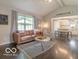 Stylish living room featuring hardwood floors, a comfortable leather couch, and ample natural light at 774 Courtney Cir, Danville, IN 46122