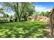 Expansive backyard featuring lush green lawn and mature trees offering shade at 8019 E Hanna Ave, Indianapolis, IN 46239