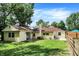 Well-maintained backyard with a mix of green grass, mature trees, and wooden fence at 8019 E Hanna Ave, Indianapolis, IN 46239