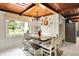 Dining room with wood ceiling, modern light fixture, and ample seating with a backyard view at 8019 E Hanna Ave, Indianapolis, IN 46239
