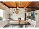 Dining room with wood ceiling, modern light fixture, and ample seating with a view to the backyard at 8019 E Hanna Ave, Indianapolis, IN 46239