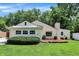 Charming home featuring professional landscaping, mature trees, and a well-maintained lawn at 8019 E Hanna Ave, Indianapolis, IN 46239