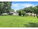 Expansive front yard showcasing a well-kept lawn and a charming home with mature trees at 8019 E Hanna Ave, Indianapolis, IN 46239