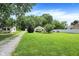 Well-maintained front yard with a charming home, a long driveway, and vibrant green lawn at 8019 E Hanna Ave, Indianapolis, IN 46239